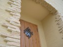 玄関も南欧風で統一。<br />
パイン調の玄関ドアとアイアン飾りです。